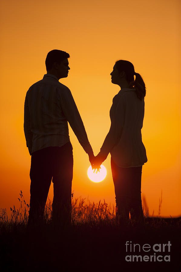 Lovers Holding Hands At Sunset In Silhouette by Lee Avison