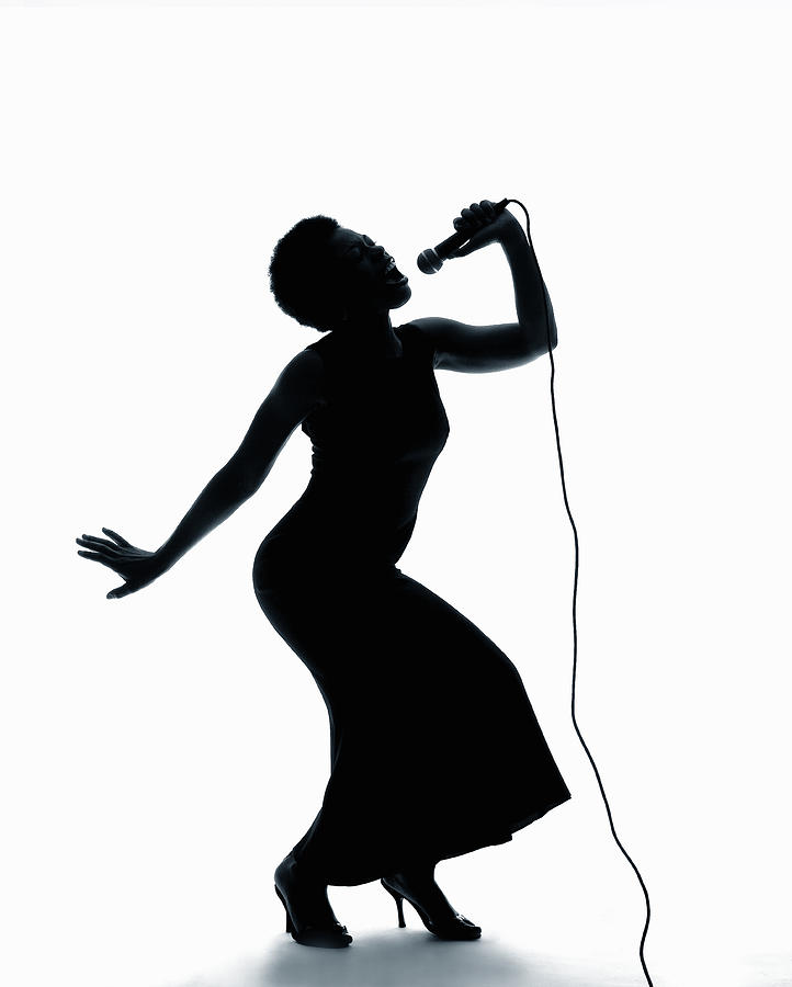 Silhouette Of Female Singer Singing On Microphone by PM Images ...