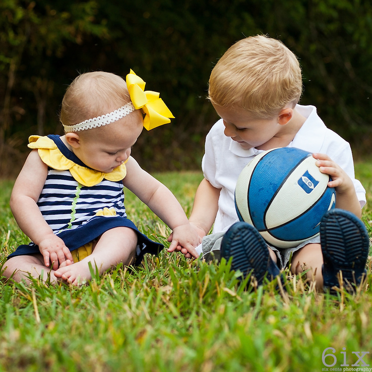 two kids holding hands in grass field | six cents photography